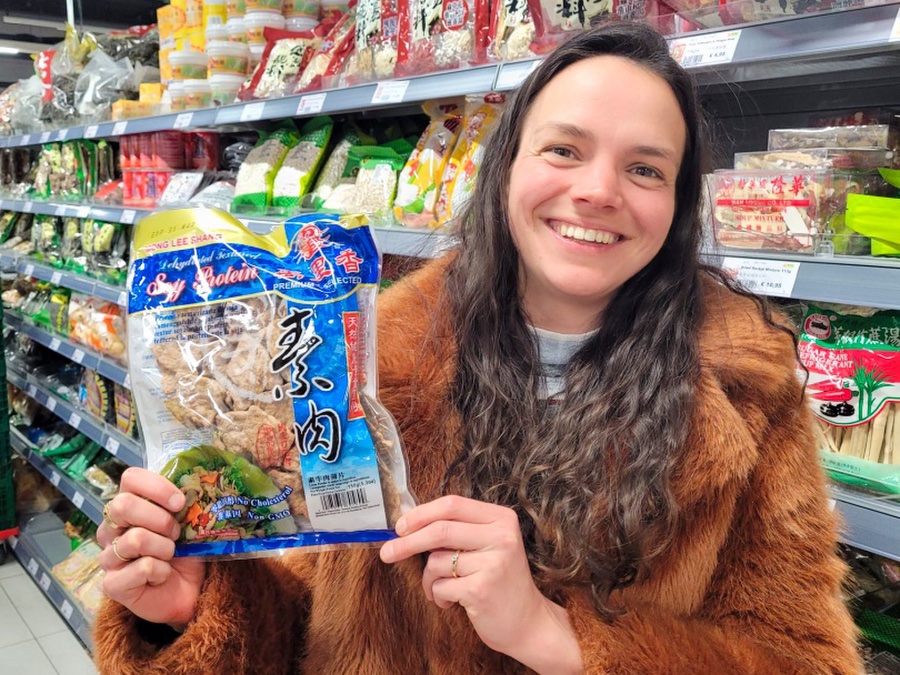 In een Toko zie je een persoon in een nep bontjas. In haar handen houdt ze een pakje met soja proteinen