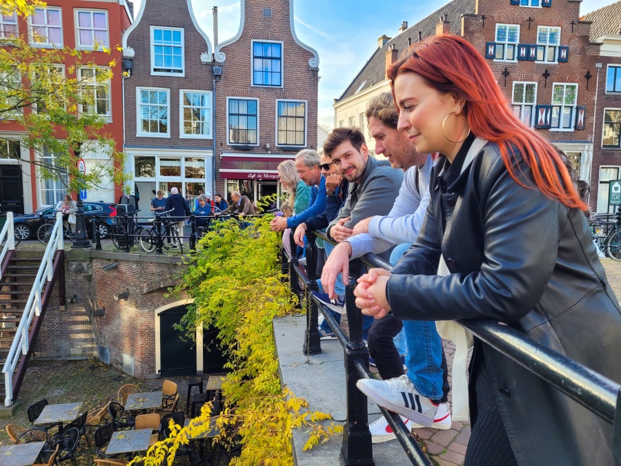 Met Utrecht op de achtergrond zie je een groep mensen over de gracht heen kijken
