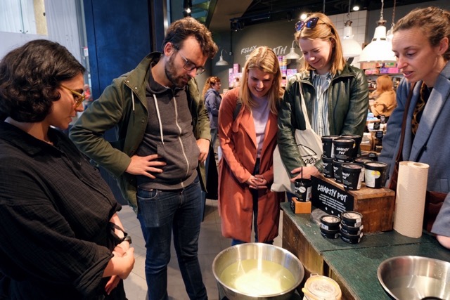 Je ziet mensen naar zeep in een wasteil kijken in een winkel