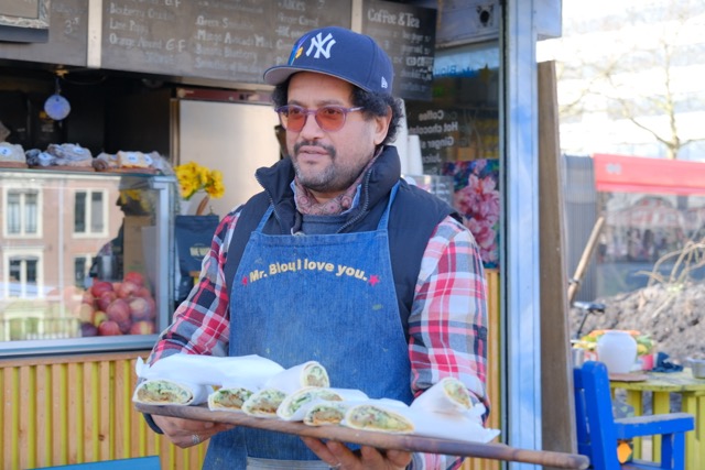 Een man met een plank vol falafel