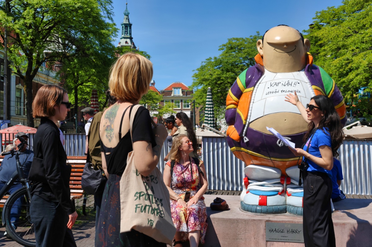 Een gids vertelt over het standbeeld Haagse Harry aan een groep deelnemers tijdens de street food tour in Den Haag.