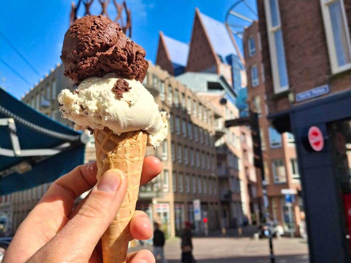 Hand met een ijshoorntje met twee bolletjes vegan ijs tijdens een food tour in Den Haag.